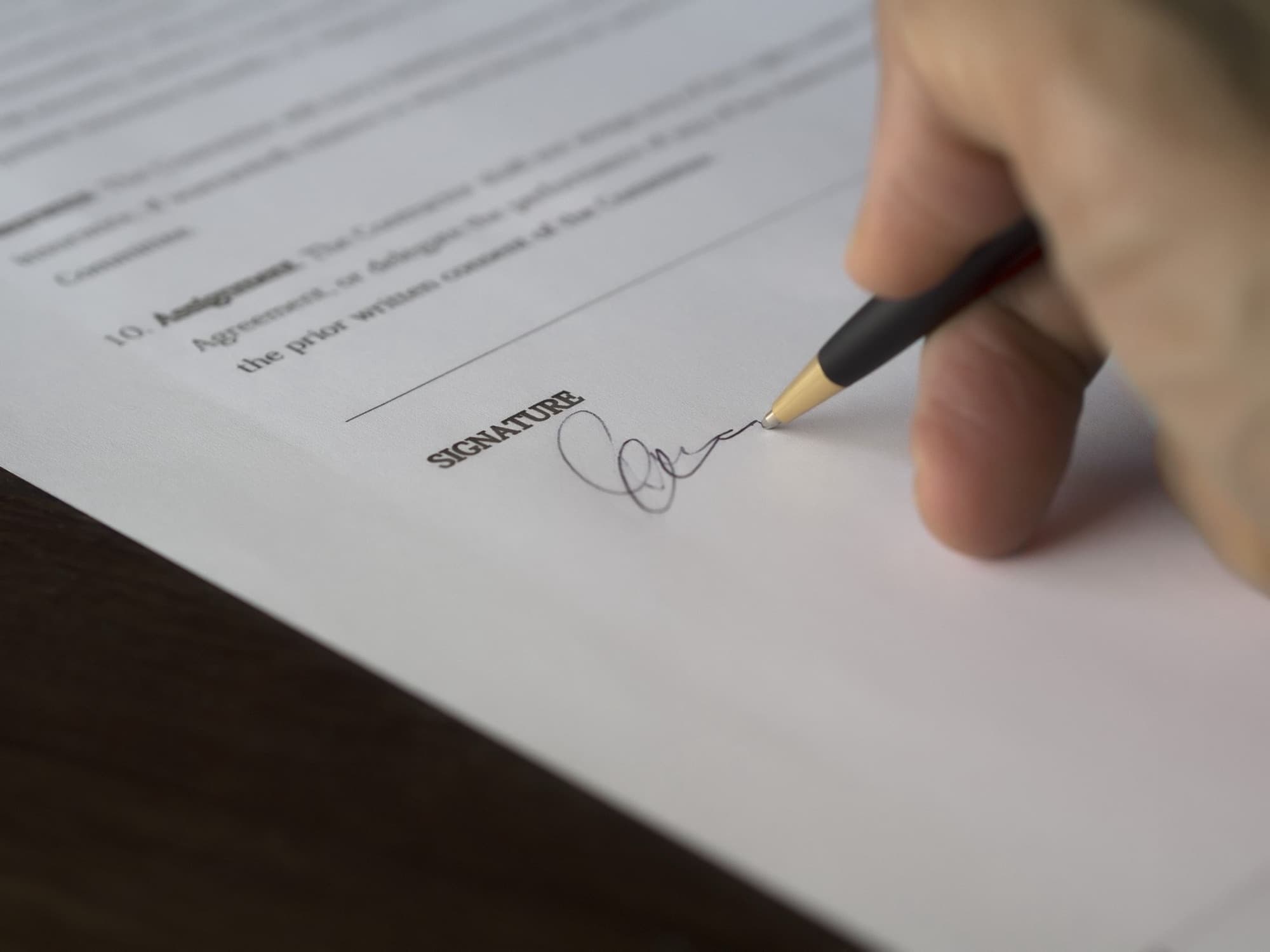 Close-up of a contract being signed with a fountain pen